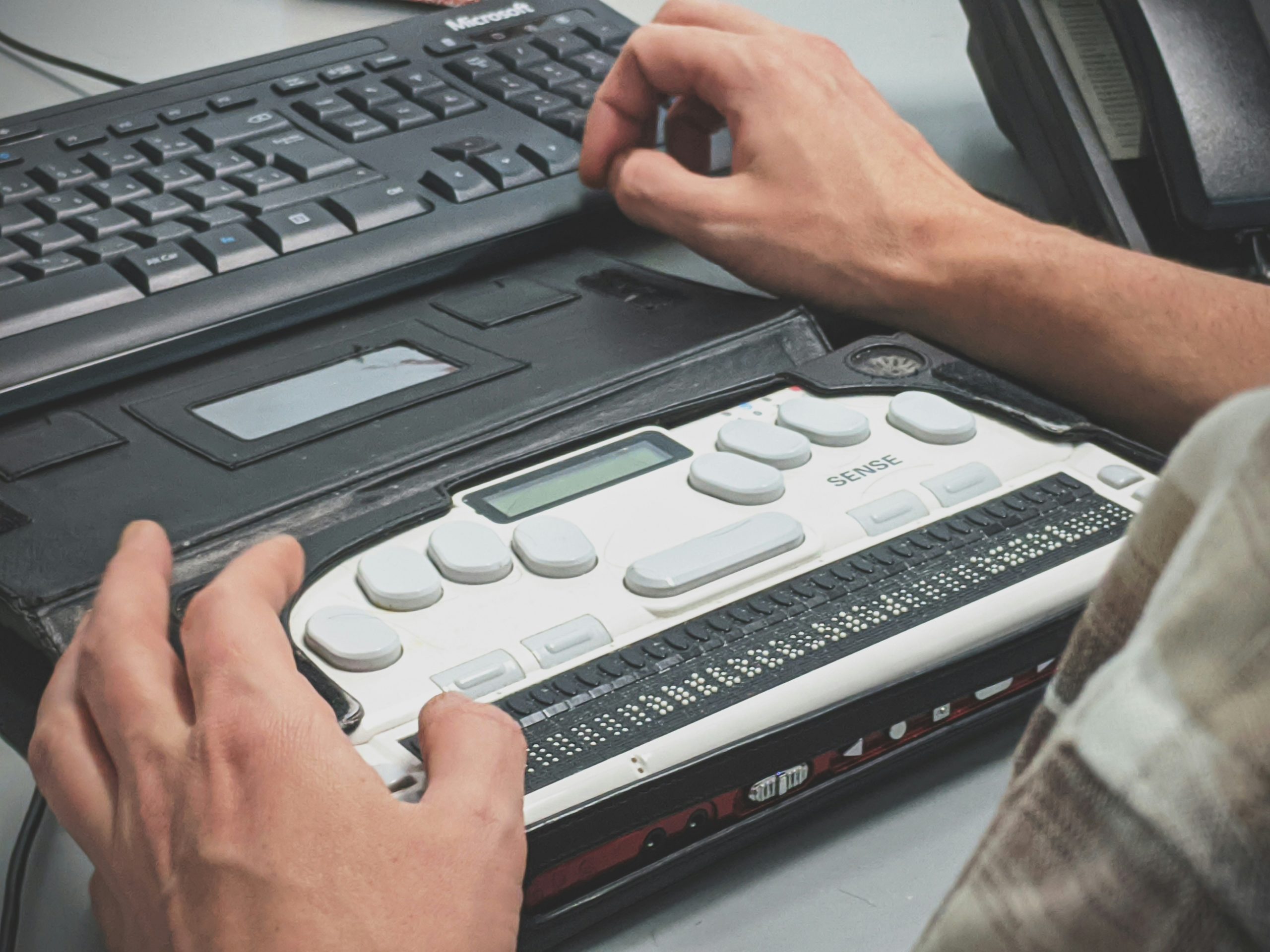Hands above a Braille screen reader